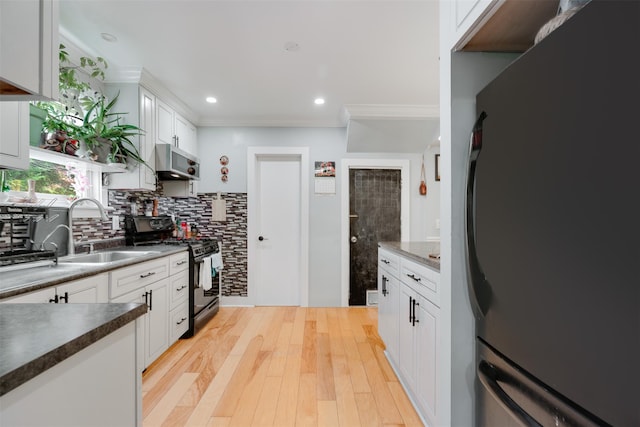 110 Pine Ave, Ossining, NY 10562 - kitchen with range with gas cooktop, freestanding refrigerator, stainless steel microwave, white cabinetry, and decorative backsplash