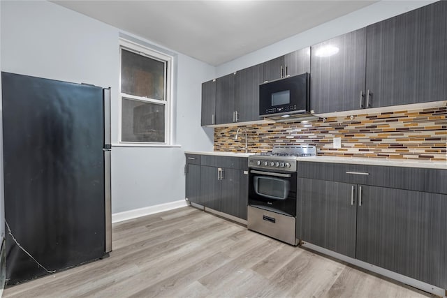 123 Elm St, Yonkers, NY 10701 - kitchen featuring stainless steel appliances, light wood-style flooring, decorative backsplash, and light countertops