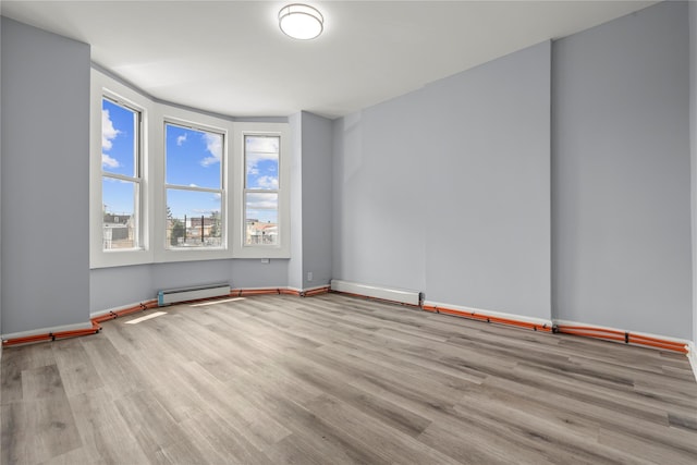 123 Elm St, Yonkers, NY 10701 - spare room featuring wood finished floors and a baseboard radiator