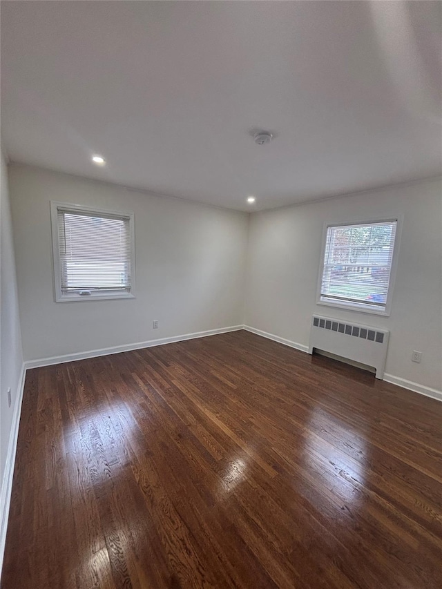 868 Oliver Ave, Westbury, NY 11590 - empty room featuring radiator, dark wood finished floors, recessed lighting, and a smoke detector