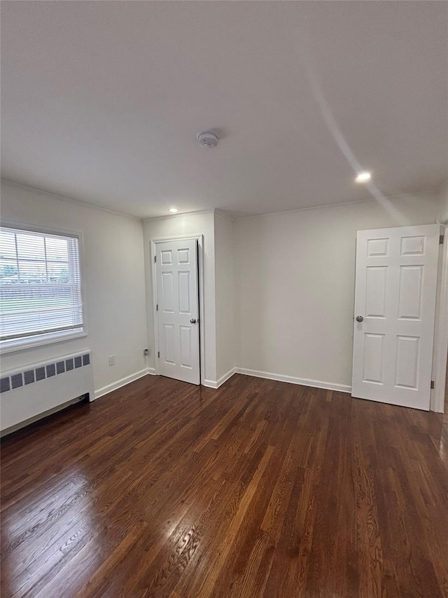 868 Oliver Ave, Westbury, NY 11590 - empty room featuring radiator heating unit, dark wood finished floors, a smoke detector, and recessed lighting