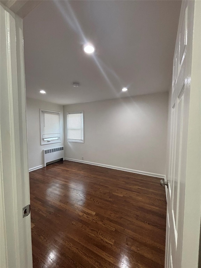 868 Oliver Ave, Westbury, NY 11590 - empty room with radiator heating unit, dark wood finished floors, and recessed lighting
