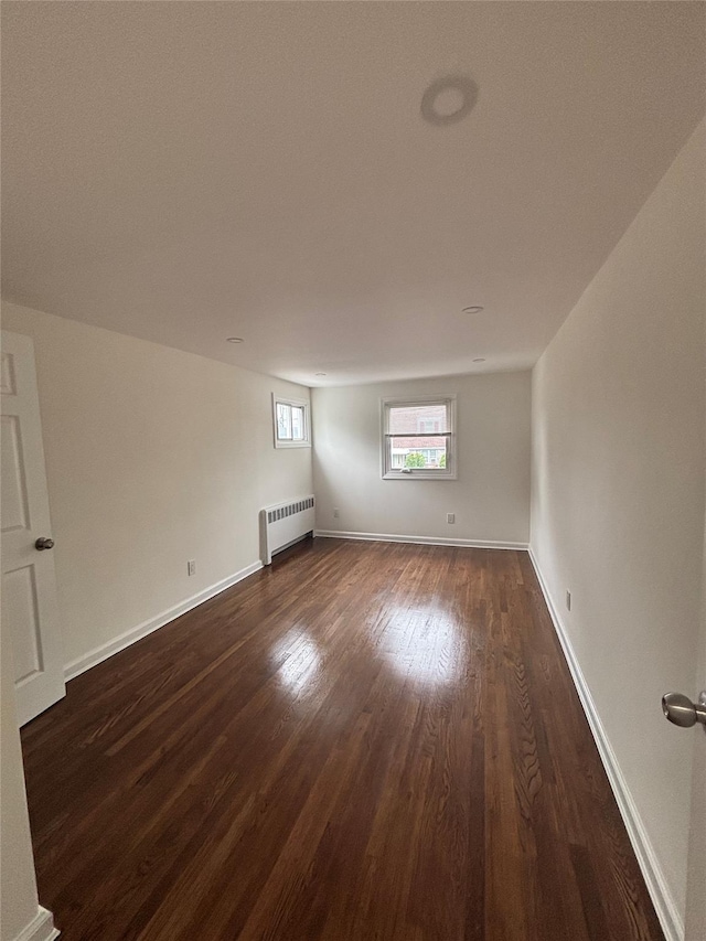 868 Oliver Ave, Westbury, NY 11590 - spare room featuring radiator heating unit and dark wood-type flooring