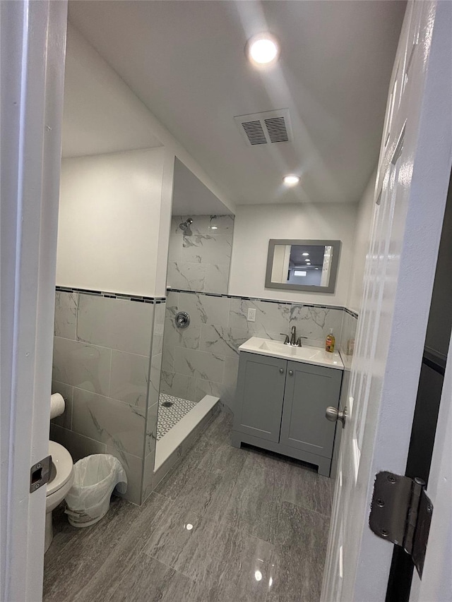 868 Oliver Ave, Westbury, NY 11590 - bathroom with tile walls, a tile shower, vanity, and recessed lighting