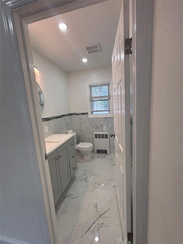 868 Oliver Ave, Westbury, NY 11590 - bathroom with radiator, marble finish flooring, vanity, tile walls, and recessed lighting