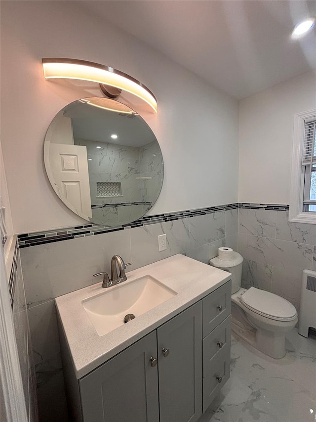 868 Oliver Ave, Westbury, NY 11590 - bathroom with tile walls, marble finish floors, vanity, radiator, and a wainscoted wall
