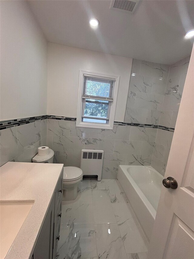 868 Oliver Ave, Westbury, NY 11590 - bathroom with radiator heating unit, vanity, recessed lighting, marble finish floors, and tile walls