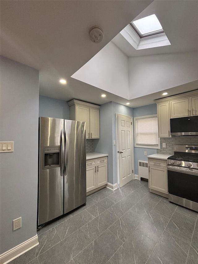 868 Oliver Ave, Westbury, NY 11590 - kitchen with appliances with stainless steel finishes, radiator, a skylight, tasteful backsplash, and light countertops