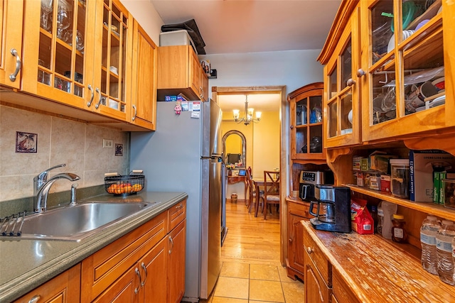 144-45 Sanford Ave Unit 6B, Flushing, NY 11355 - kitchen featuring freestanding refrigerator, decorative backsplash, brown cabinets, and a chandelier