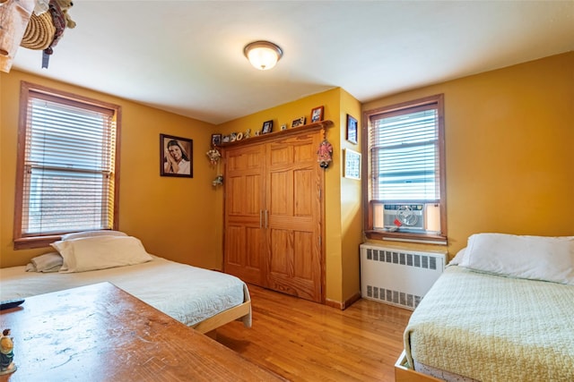 144-45 Sanford Ave Unit 6B, Flushing, NY 11355 - bedroom featuring radiator, light wood finished floors, cooling unit, and multiple windows