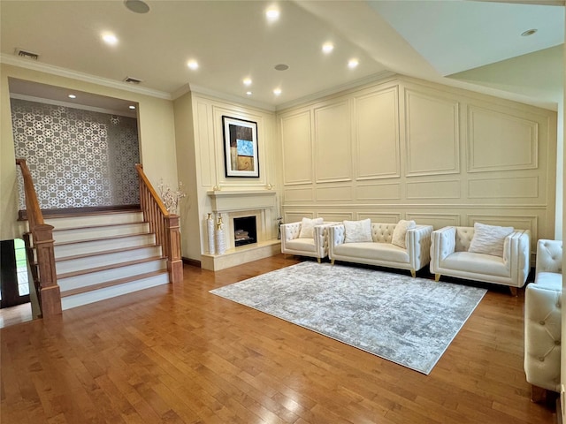 10 Hazelwood Ct, Jericho, NY 11753 - living room with a decorative wall, crown molding, wallpapered walls, stairway, and hardwood / wood-style floors