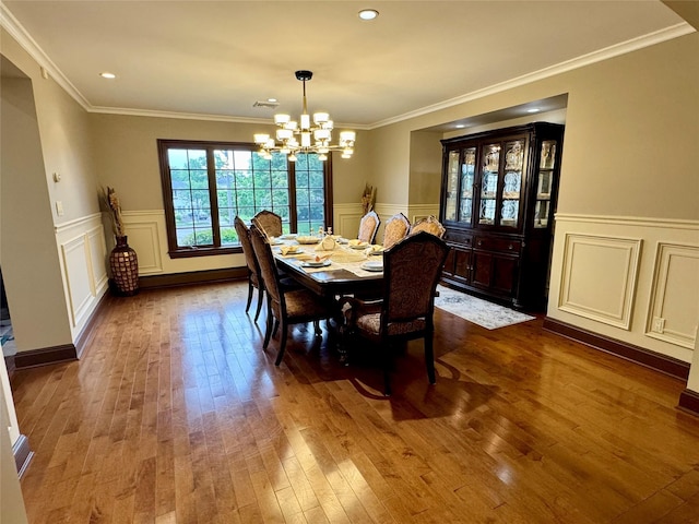 10 Hazelwood Ct, Jericho, NY 11753 - dining room with dark wood-type flooring, a chandelier, wainscoting, a decorative wall, and crown molding