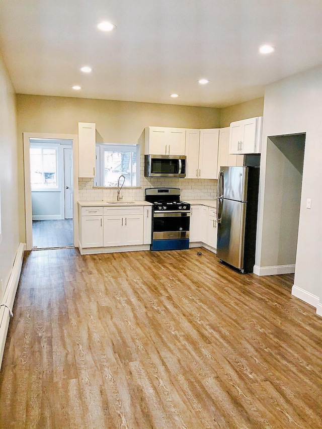 114 Park Ave, Mount Vernon, NY 10550 - kitchen with stainless steel appliances, light countertops, backsplash, white cabinetry, and recessed lighting