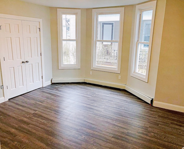 114 Park Ave, Mount Vernon, NY 10550 - unfurnished bedroom with dark wood-type flooring, a baseboard heating unit, and a closet