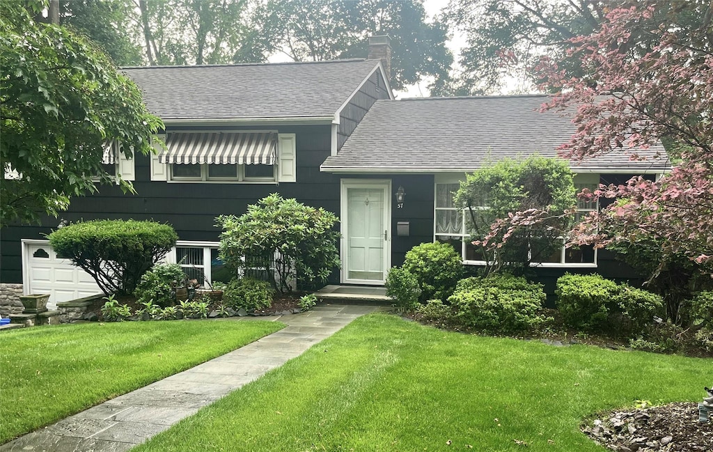 57 Central Ave, Tappan, NY 10983 - split level home with roof with shingles, a front yard, and a chimney