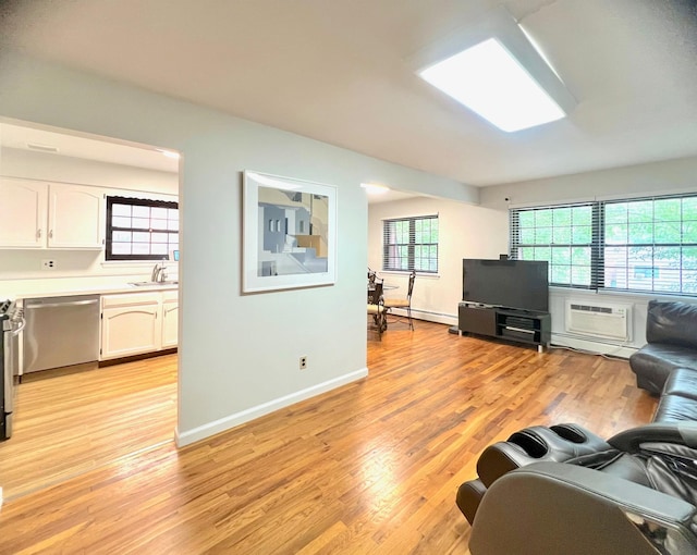 22035 67th Ave Unit C, Bayside, NY 11364 - living room with light wood-style flooring, a baseboard heating unit, and an AC wall unit