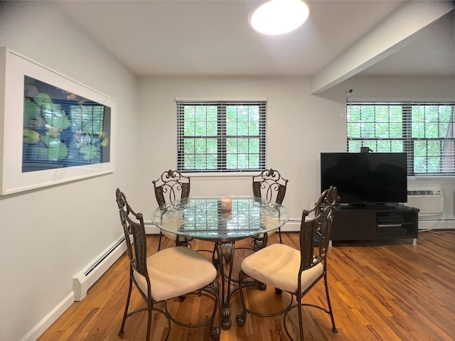22035 67th Ave Unit C, Bayside, NY 11364 - dining area featuring healthy amount of natural light, wood finished floors, a wall mounted AC, and a baseboard radiator