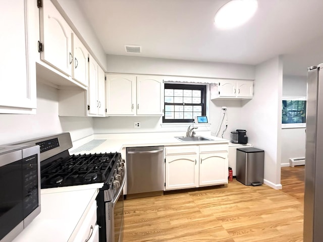 22035 67th Ave Unit C, Bayside, NY 11364 - kitchen with stainless steel appliances, white cabinets, a baseboard radiator, and light countertops