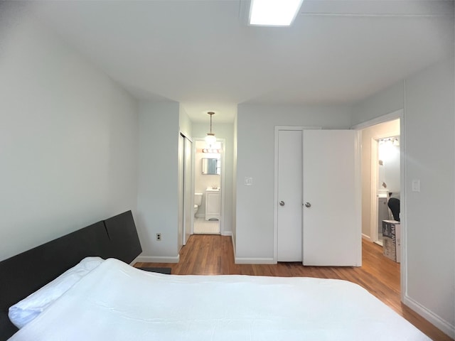 22035 67th Ave Unit C, Bayside, NY 11364 - bedroom with wood finished floors, ensuite bath, and washer / clothes dryer