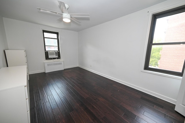 84-01 Main St Unit 410, Briarwood, NY 11435 - empty room with radiator, dark wood finished floors, cooling unit, and a ceiling fan