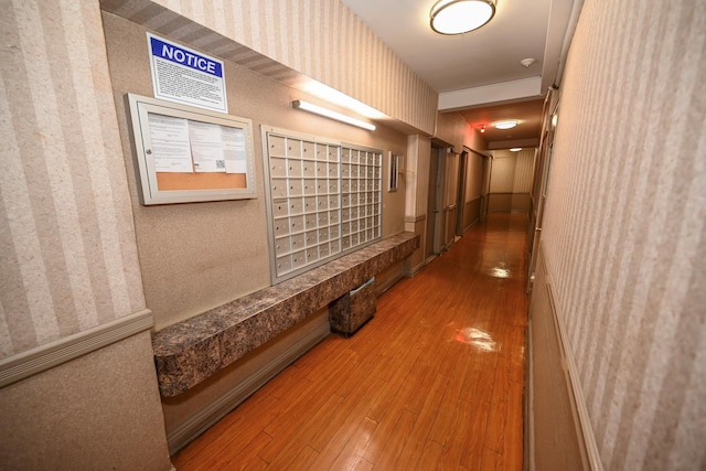 84-01 Main St Unit 410, Briarwood, NY 11435 - corridor featuring mail area, wallpapered walls, and hardwood / wood-style flooring