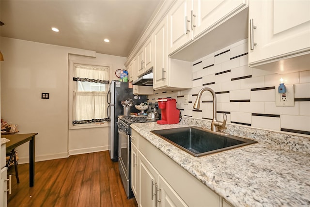 92-05 218th Pl, Queens Village, NY 11428 - kitchen with stainless steel range with gas cooktop, under cabinet range hood, decorative backsplash, dark wood finished floors, and white cabinets
