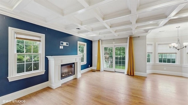 60 E Minerva Rd, Lindenhurst, NY 11757 - unfurnished living room featuring a chandelier, wood finished floors, healthy amount of natural light, a glass covered fireplace, and beam ceiling