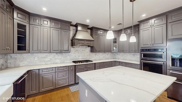 60 E Minerva Rd, Lindenhurst, NY 11757 - kitchen with premium range hood, stainless steel appliances, glass insert cabinets, a center island, and light wood finished floors