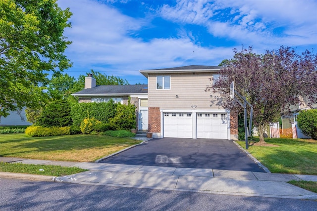 18 Sutton Ter, Jericho, NY 11753 - view of front of property with an attached garage, asphalt driveway, a front yard, a chimney, and brick siding