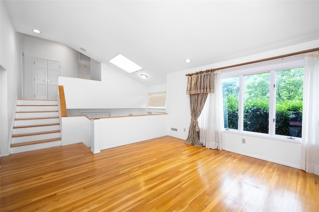18 Sutton Ter, Jericho, NY 11753 - unfurnished living room featuring a skylight, light wood finished floors, recessed lighting, stairway, and lofted ceiling