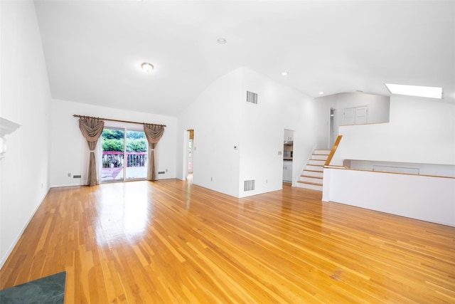 18 Sutton Ter, Jericho, NY 11753 - unfurnished living room featuring light wood-type flooring, high vaulted ceiling, and a skylight