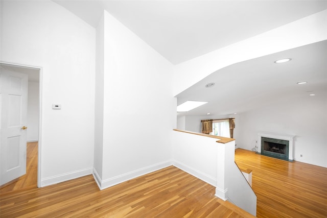 18 Sutton Ter, Jericho, NY 11753 - corridor with vaulted ceiling, an upstairs landing, a skylight, light wood-type flooring, and recessed lighting