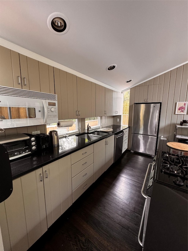 487 Tarpon Walk, Fire Island Pines, NY 11782 - kitchen with appliances with stainless steel finishes, dark wood-style floors, dark countertops, and wood walls