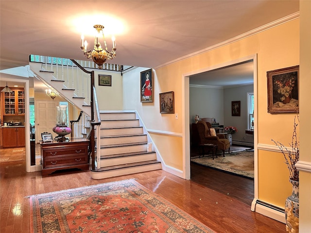 8 Rolling Dr, Brookville, NY 11545 - staircase with a baseboard heating unit, ornamental molding, hardwood / wood-style flooring, and a chandelier