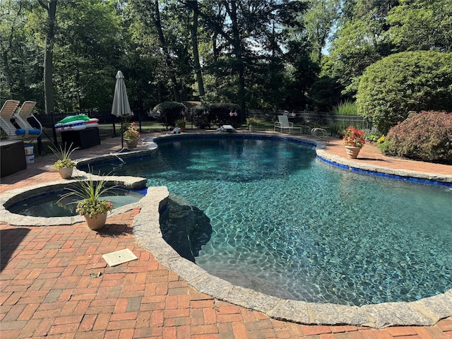 8 Rolling Dr, Brookville, NY 11545 - view of swimming pool featuring a patio, a fenced backyard, a pool with connected hot tub, and view of wooded area