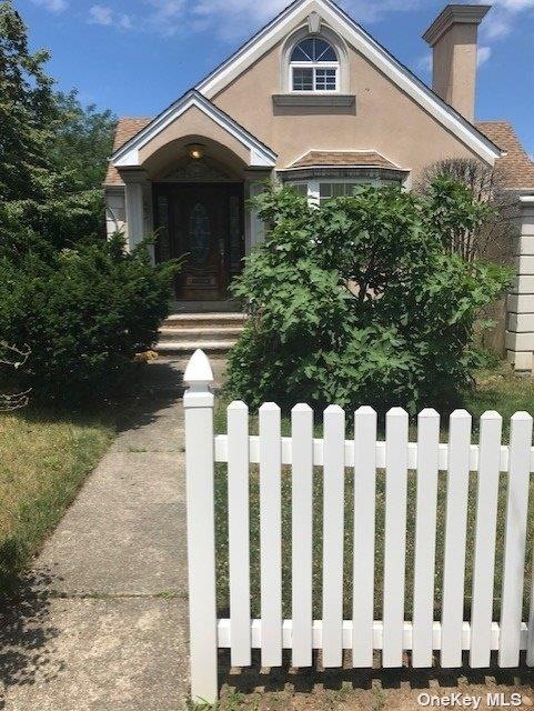 168-03 Cryders Ln, Whitestone, NY 11357 - view of front of house with a chimney and stucco siding