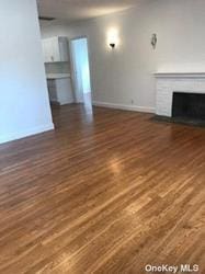 168-03 Cryders Ln, Whitestone, NY 11357 - unfurnished living room featuring wood finished floors and a fireplace