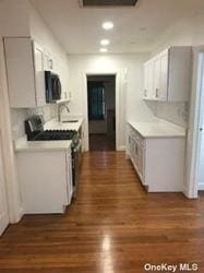 168-03 Cryders Ln, Whitestone, NY 11357 - kitchen with range, light countertops, wood finished floors, black microwave, and recessed lighting