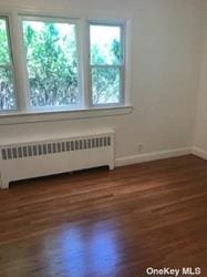 168-03 Cryders Ln, Whitestone, NY 11357 - spare room with radiator and wood finished floors