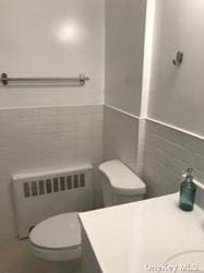 168-03 Cryders Ln, Whitestone, NY 11357 - bathroom featuring radiator heating unit, vanity, and tile walls
