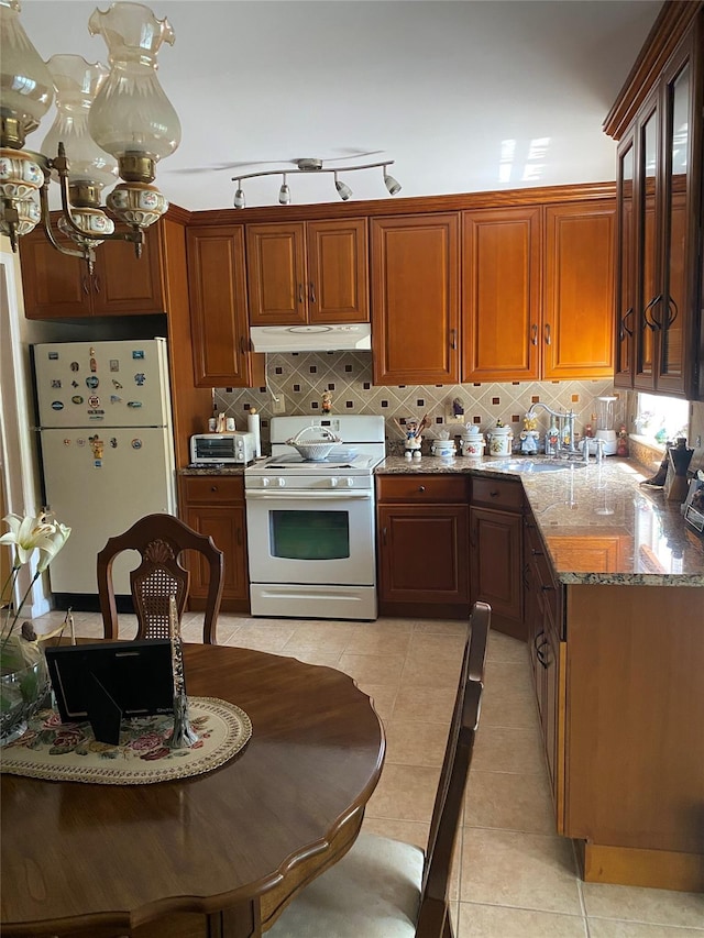 2896 Coddington Ave, Bronx, NY 10461 - kitchen with white appliances, under cabinet range hood, light stone counters, decorative backsplash, and light tile patterned floors