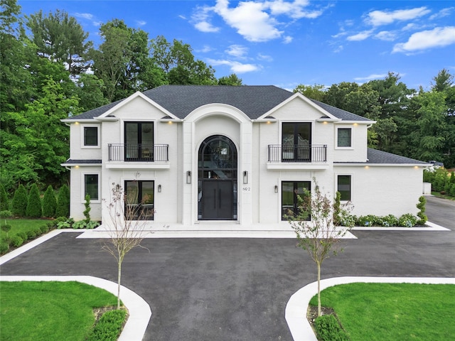 2 Maple Way, Woodbury, NY 11797 - view of front facade with a balcony, roof with shingles, and view of scattered trees