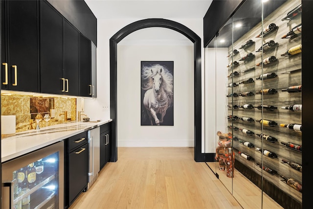 2 Maple Way, Woodbury, NY 11797 - wine cellar featuring beverage cooler, light wood finished floors, and bar with sink