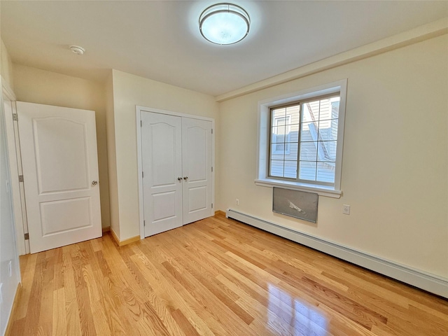 1604 Robertson Pl, Bronx, NY 10465 - unfurnished bedroom with baseboard heating, light wood-type flooring, and a closet