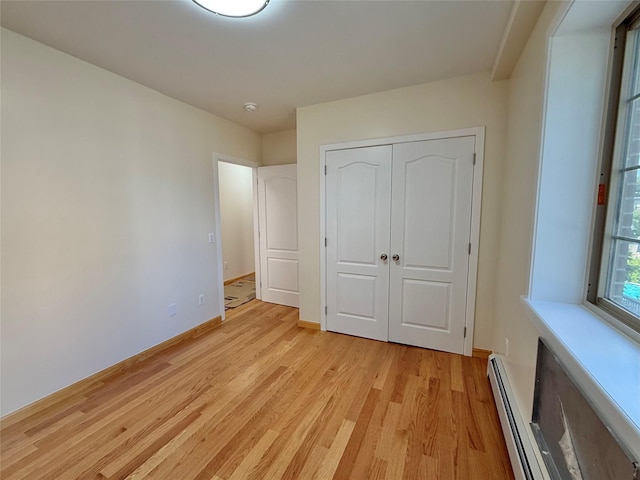1604 Robertson Pl, Bronx, NY 10465 - unfurnished bedroom with a baseboard radiator, light wood-style floors, and a closet