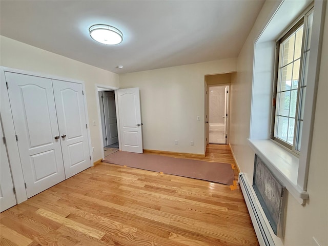 1604 Robertson Pl, Bronx, NY 10465 - unfurnished bedroom featuring light wood finished floors, a baseboard heating unit, and a closet