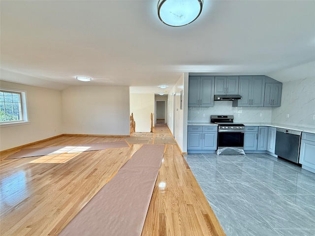 1604 Robertson Pl, Bronx, NY 10465 - kitchen featuring stainless steel appliances, under cabinet range hood, light countertops, tasteful backsplash, and open floor plan