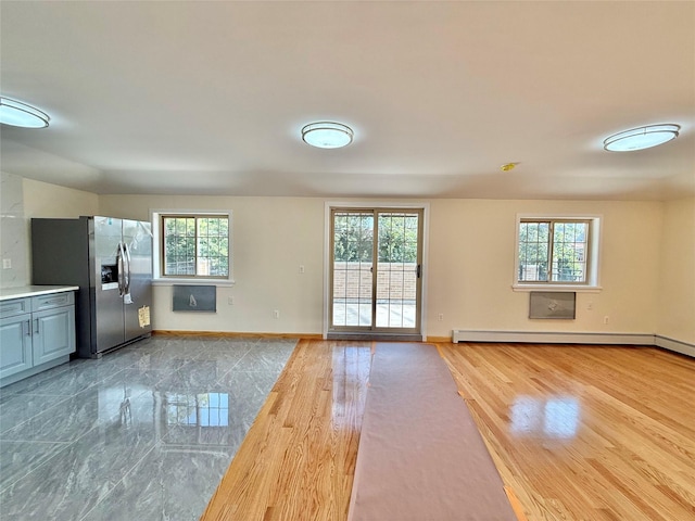 1604 Robertson Pl, Bronx, NY 10465 - unfurnished living room with healthy amount of natural light, baseboard heating, and wood finished floors
