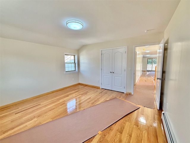 1604 Robertson Pl, Bronx, NY 10465 - unfurnished bedroom featuring a baseboard heating unit, light wood-style flooring, multiple windows, and a closet
