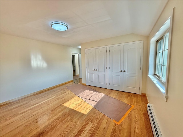 1604 Robertson Pl, Bronx, NY 10465 - unfurnished bedroom featuring a baseboard heating unit, two closets, wood finished floors, multiple windows, and vaulted ceiling